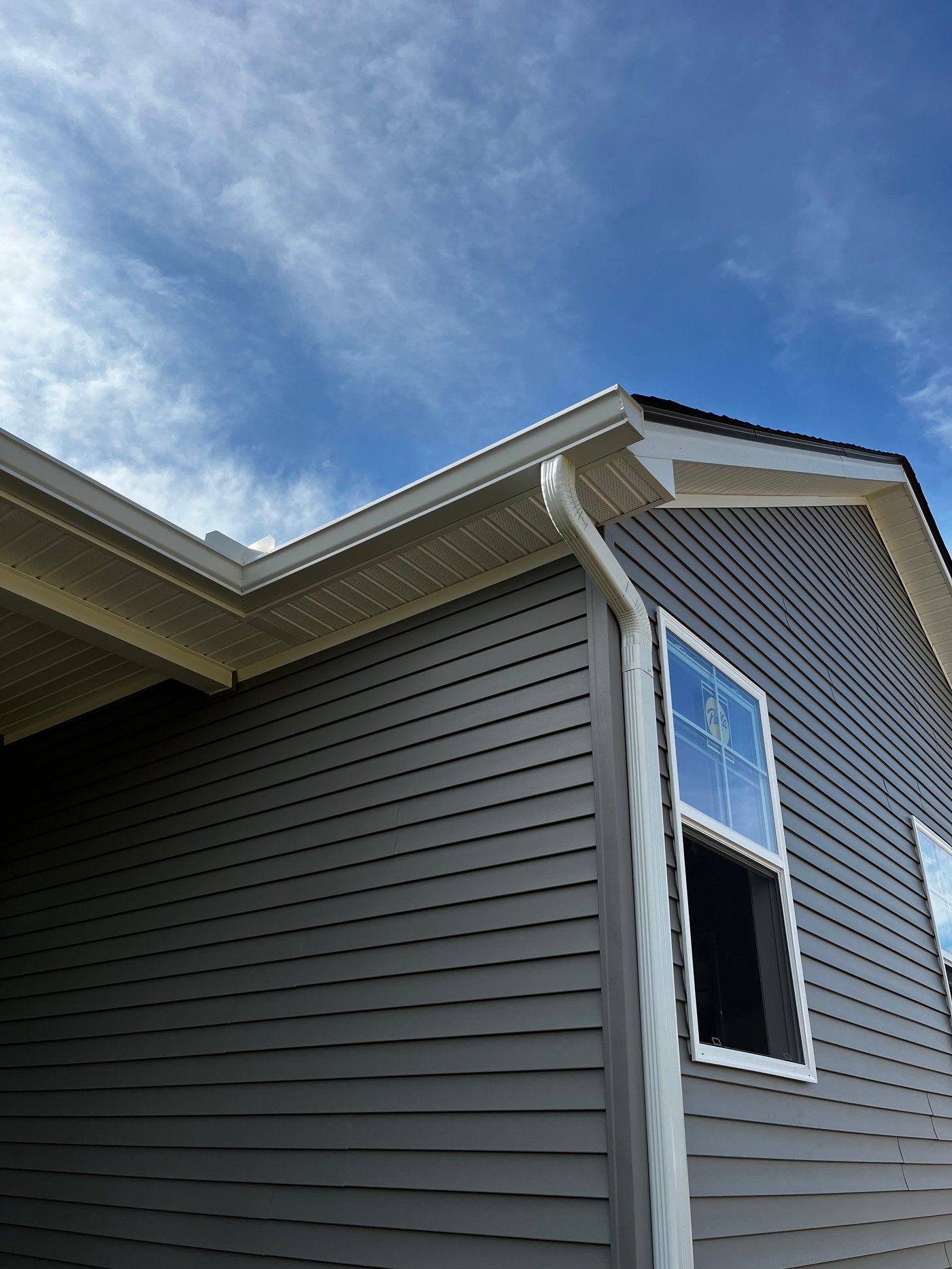Corner detail on a dark-siding new-construction home by Gutter And Covers, Cookeville